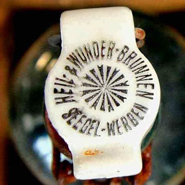 Weißer Glasflaschendeckel mit geprägter Schrift, Seegel-Werben Heil- & Wunder-Brunnen