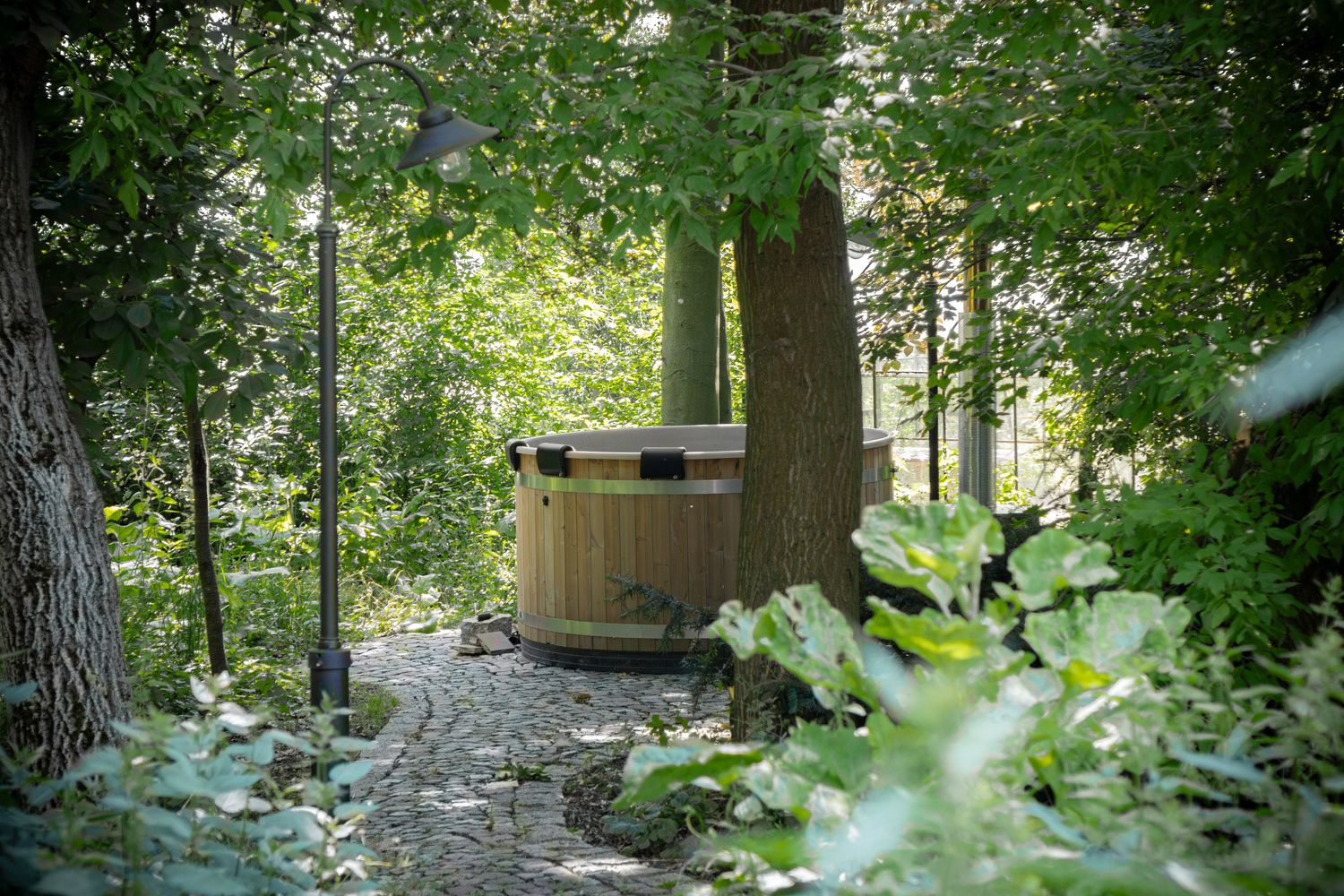 Hot Tub inmitten von Bäumen und grünen Sträuchern