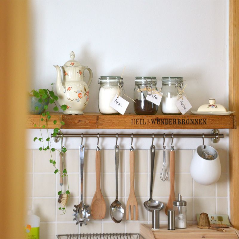 Küchenregal mit Mehl, Zucker und Kaffee, darunter hängende Küchenwerkzeuge