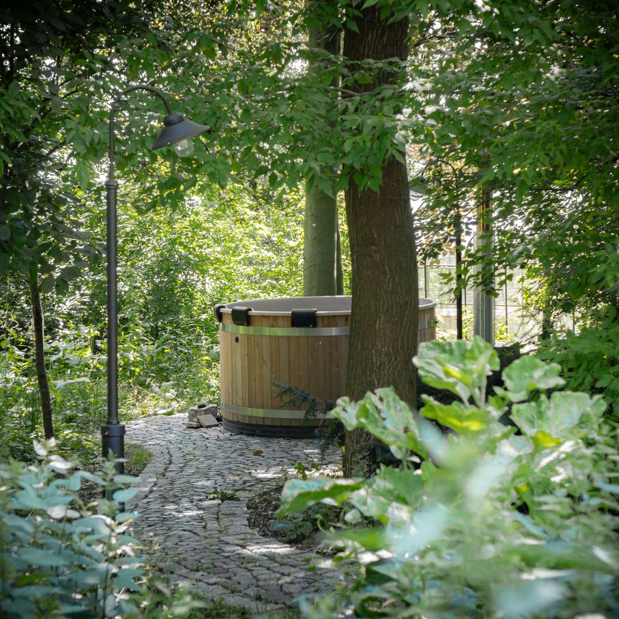 Hot Tub inmitten von Bäumen und grünen Sträuchern